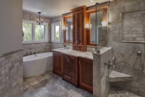 custom bathroom with tub, double sink, walk in shower and cabinetry