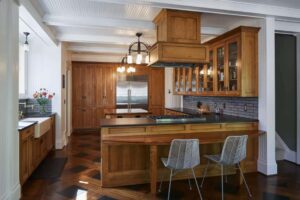 kitchen with wood cabintry, custom tile backsplash and wood floor