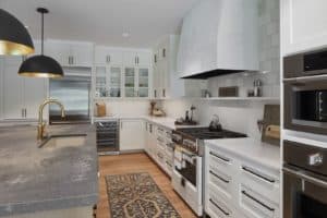 custom kitchen with white cabinets, gas stove and beautiful countertops